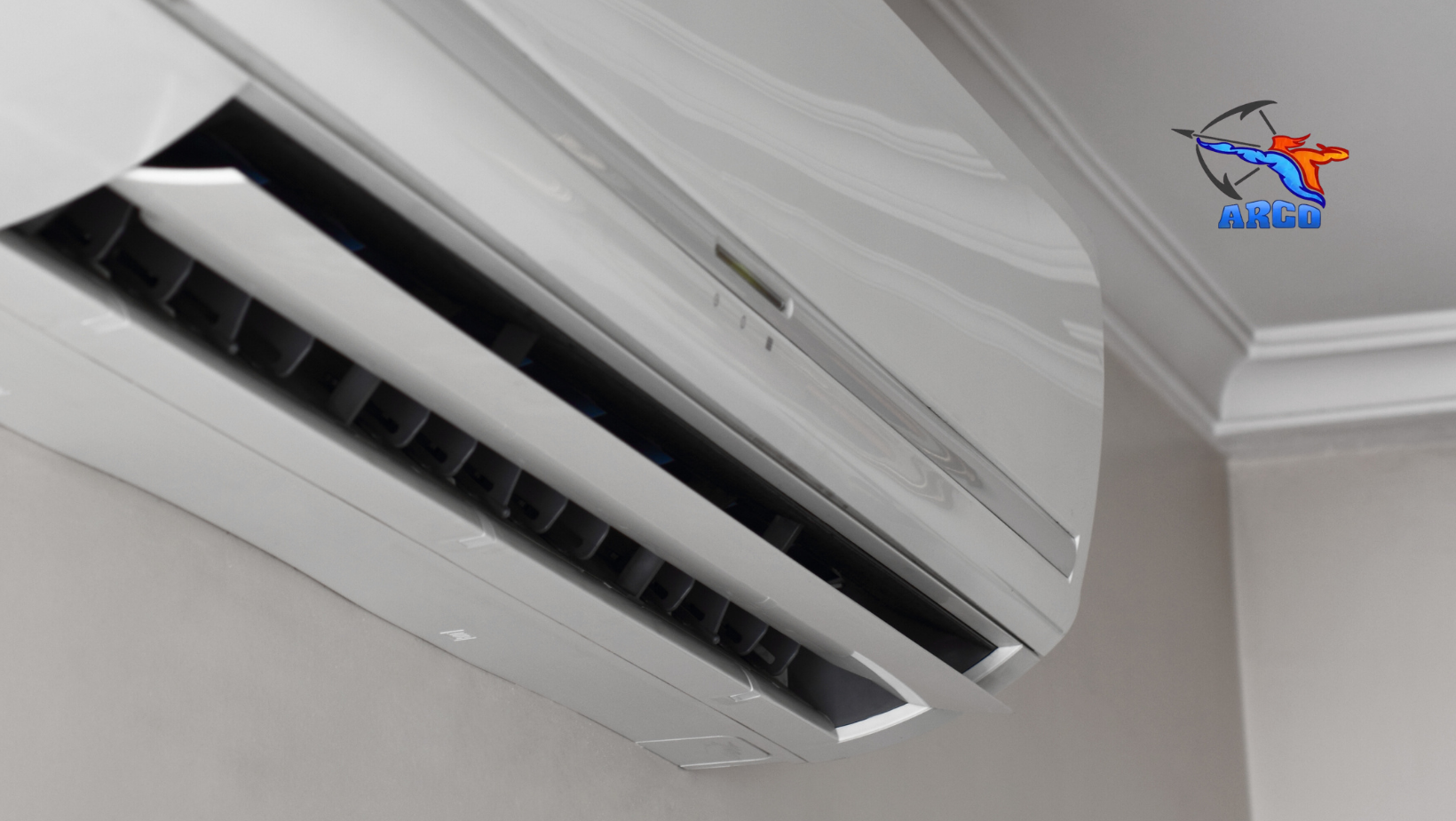 A white mini split air conditioner is hanging from the ceiling in a room.