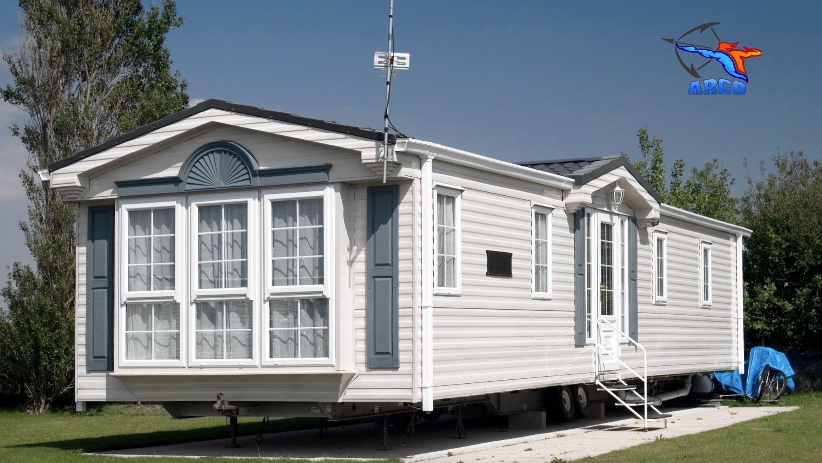 Roof of a mobile home is parked in a grassy field.