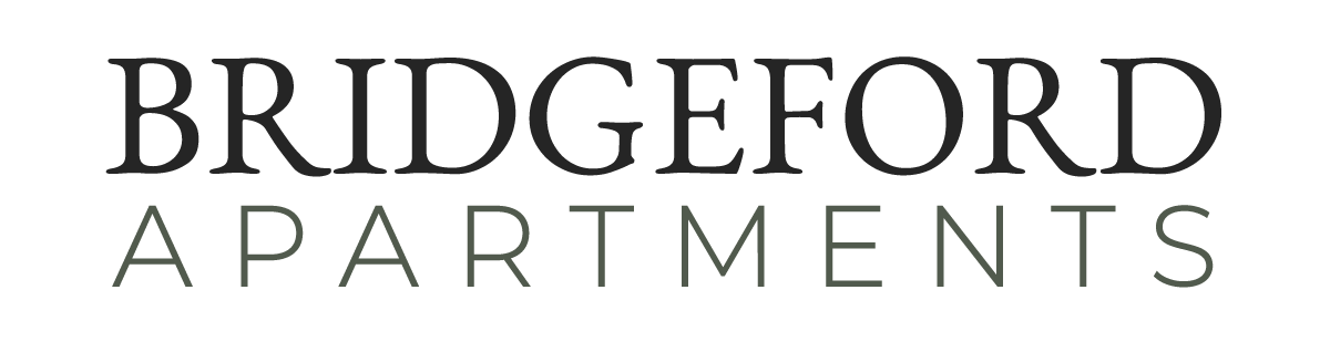 "Auburn Creek Apartments logo with brown text and the word 'APARTMENTS' below in a lighter color."