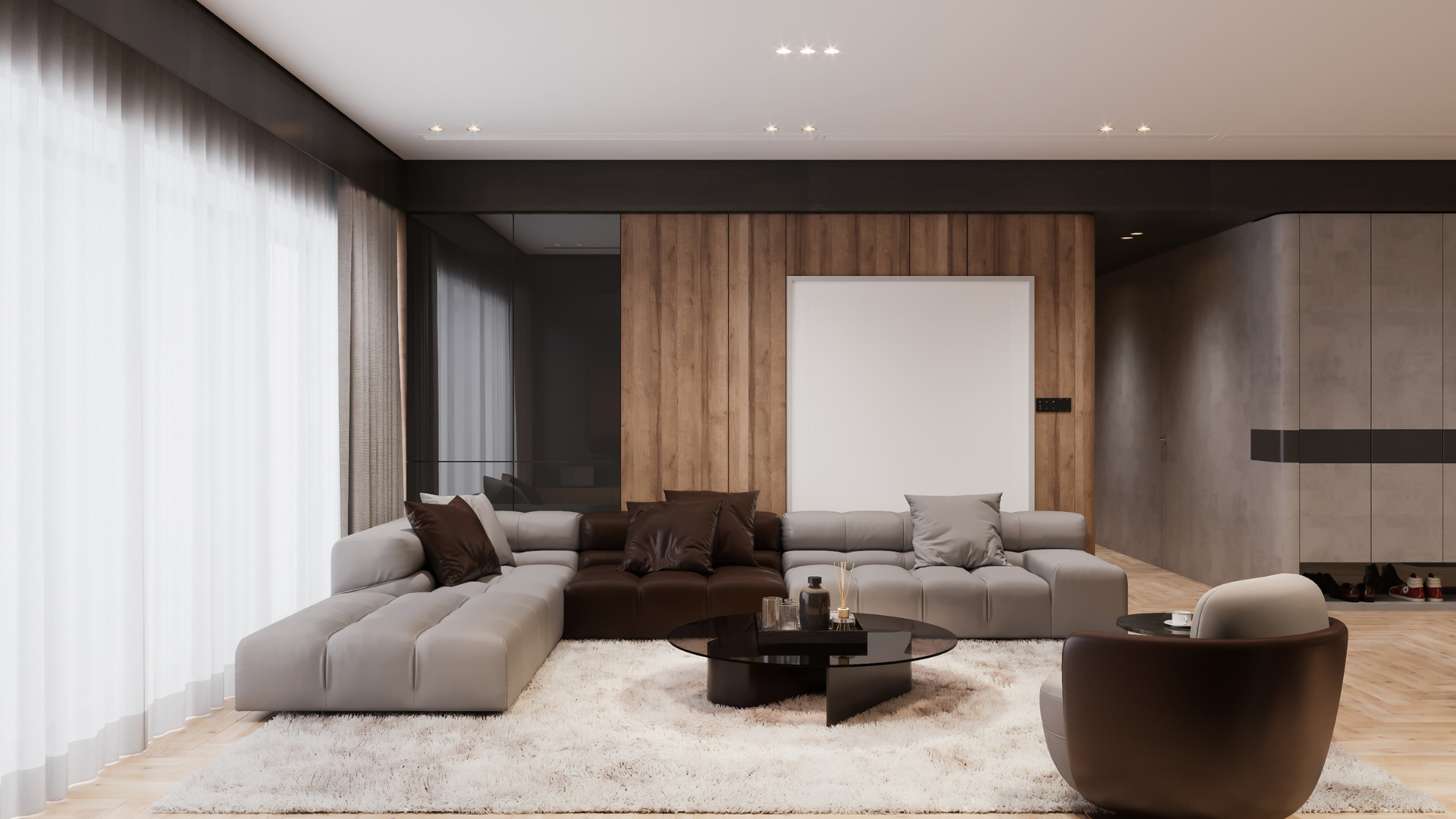 Modern living room with a large gray and brown modular sofa, a dark coffee table, and area rug in a minimalist setting.