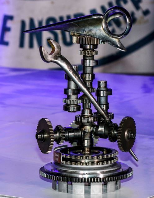 A statue of a wrench sitting on top of gears