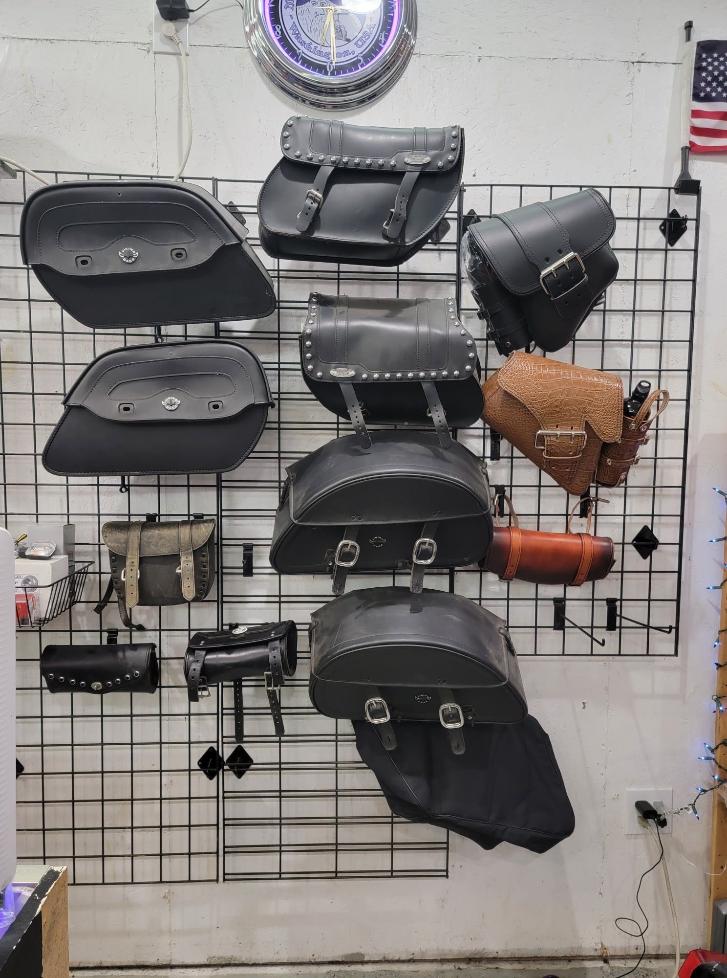 A bunch of motorcycle saddle bags are hanging on a wall