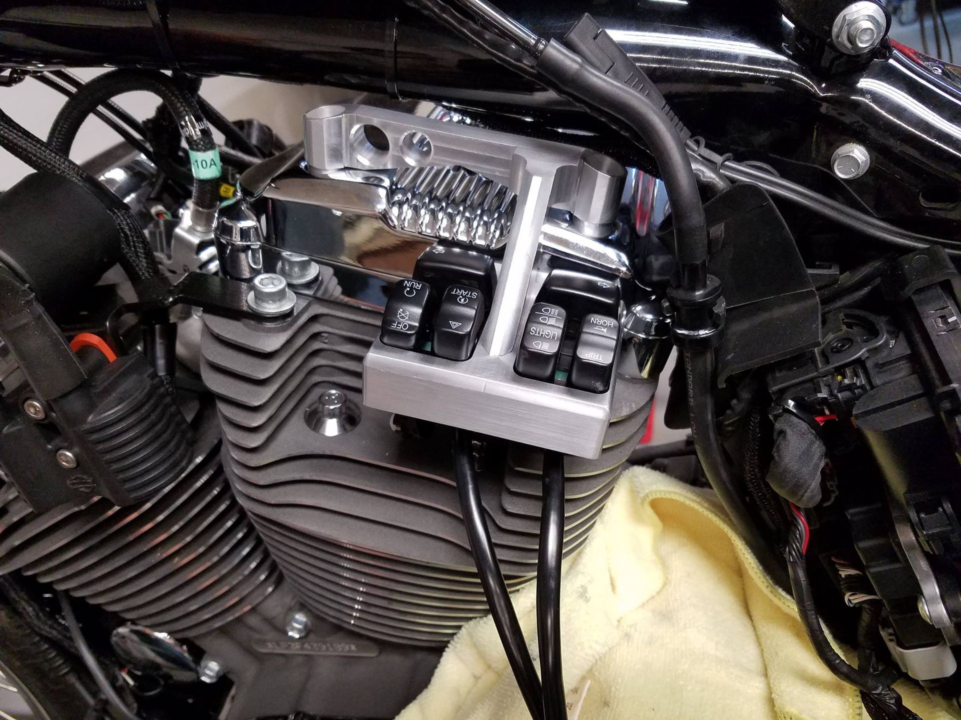 A close up of a motorcycle engine with a yellow cloth on it.