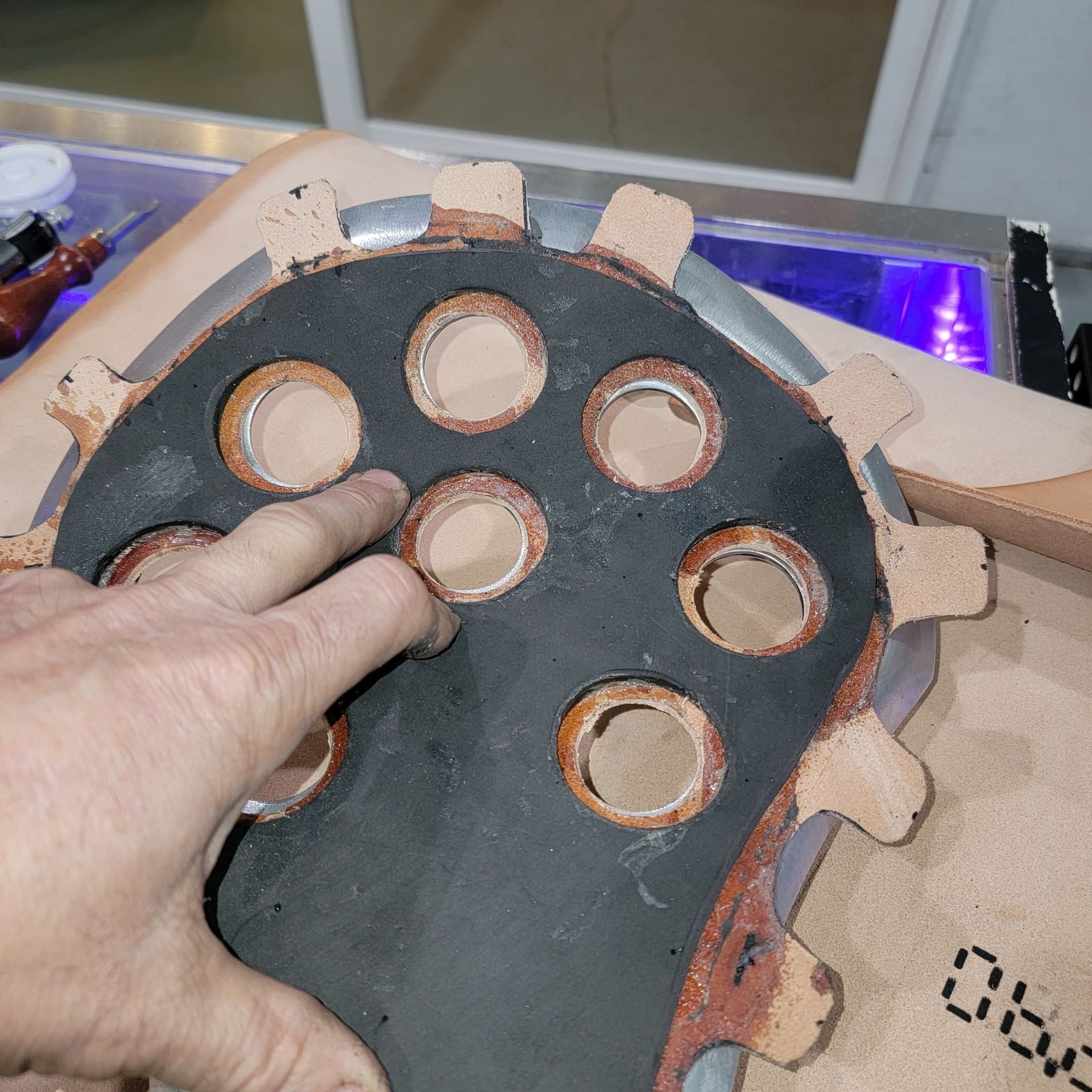 A person is holding a piece of rubber with holes in it