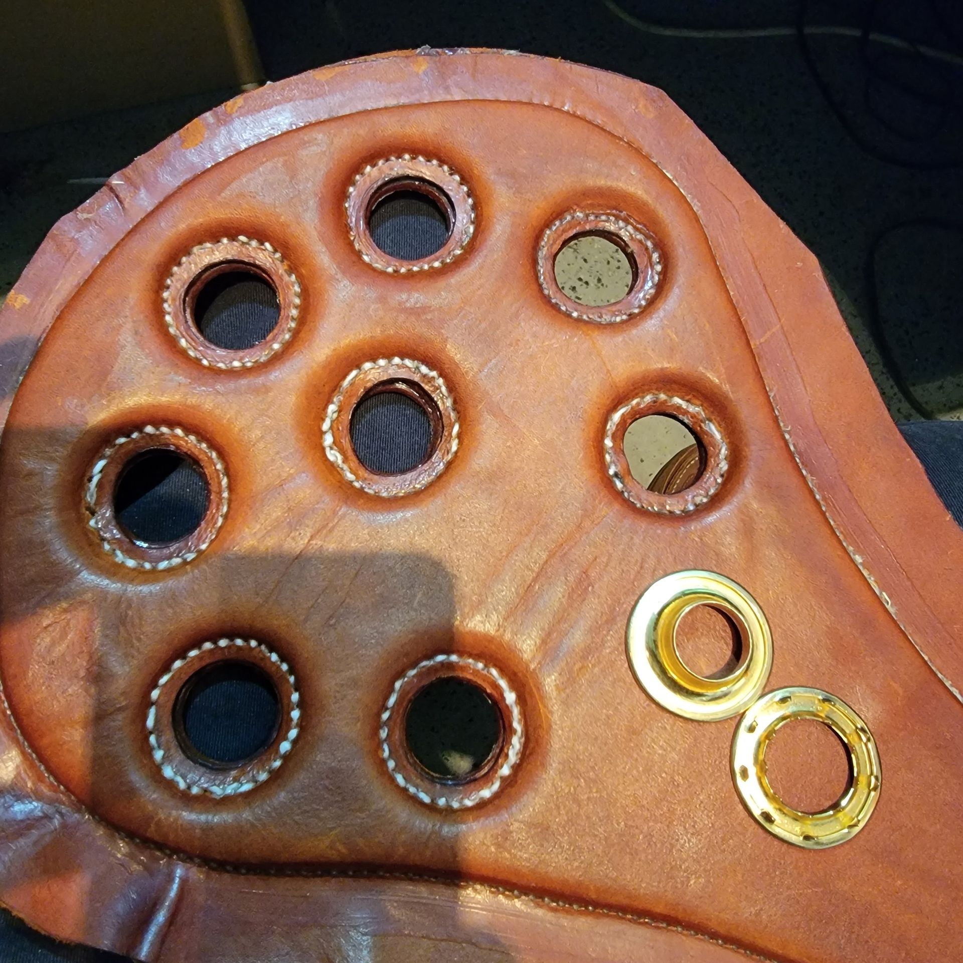 A piece of brown leather with holes in it