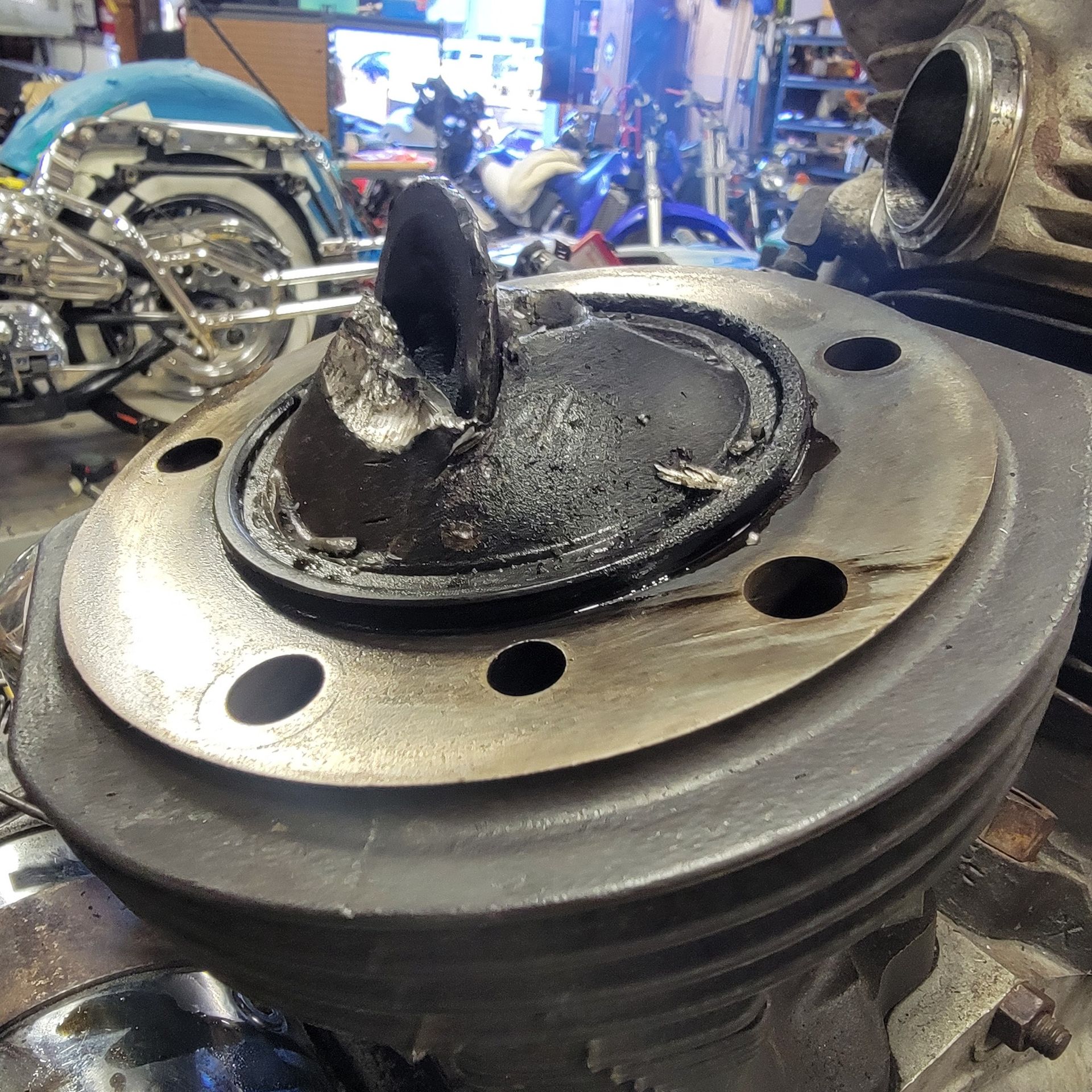 A close up of a motorcycle engine with a motorcycle in the background