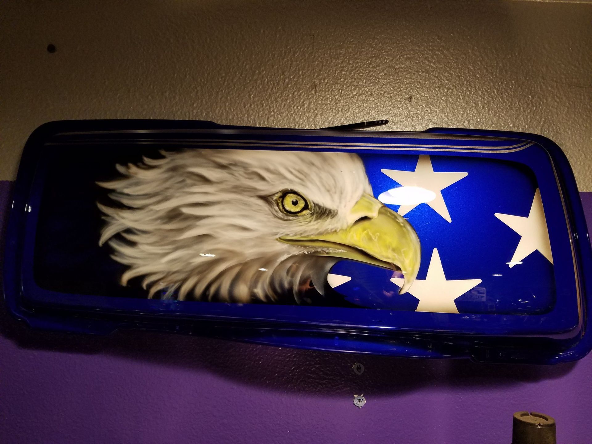 A bald eagle is painted on the side of a blue vehicle