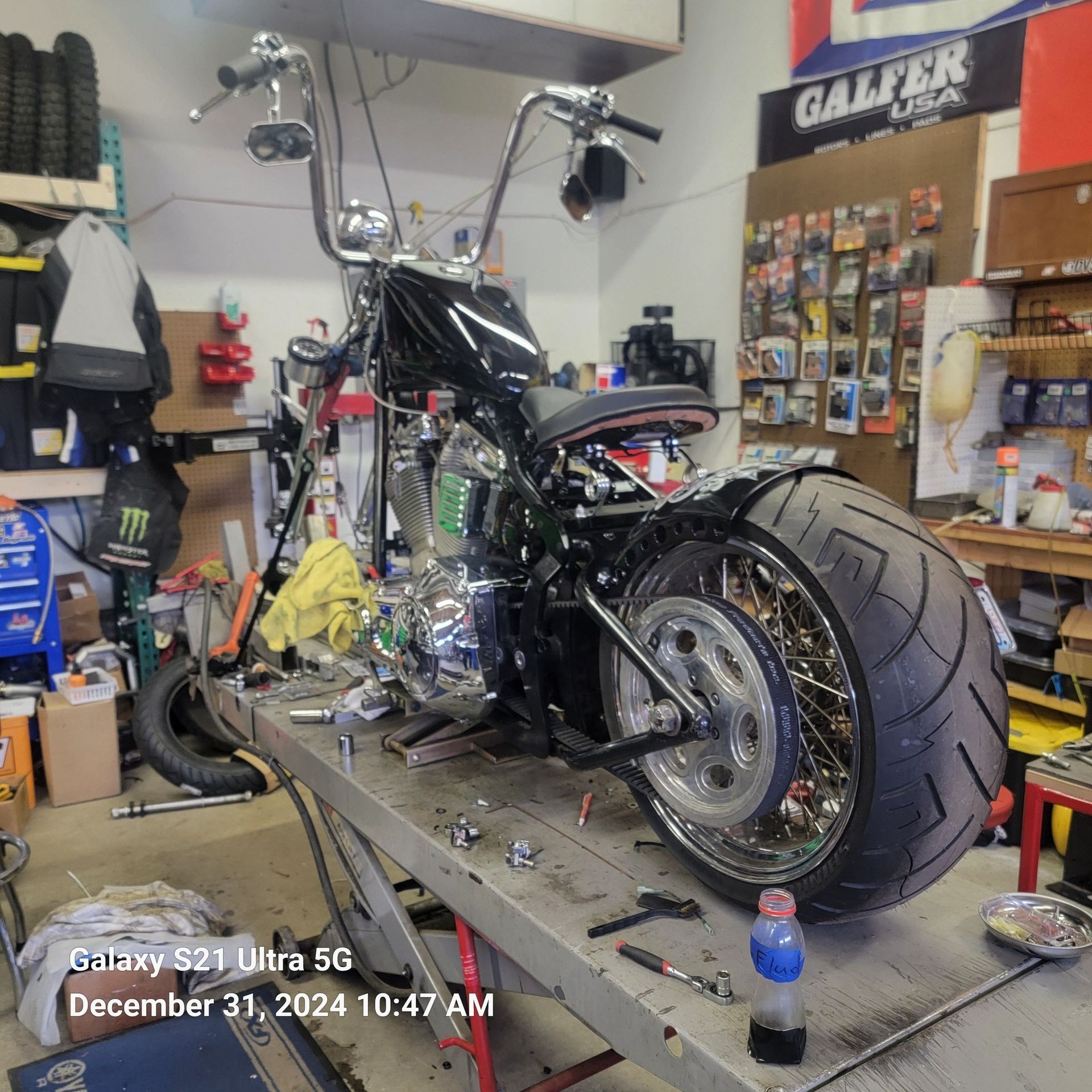 A motorcycle is sitting on a table in a garage.