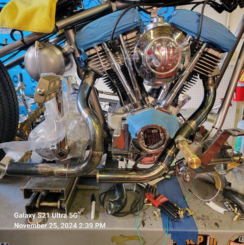 A galaxy s21 ultra is sitting on top of a motorcycle engine