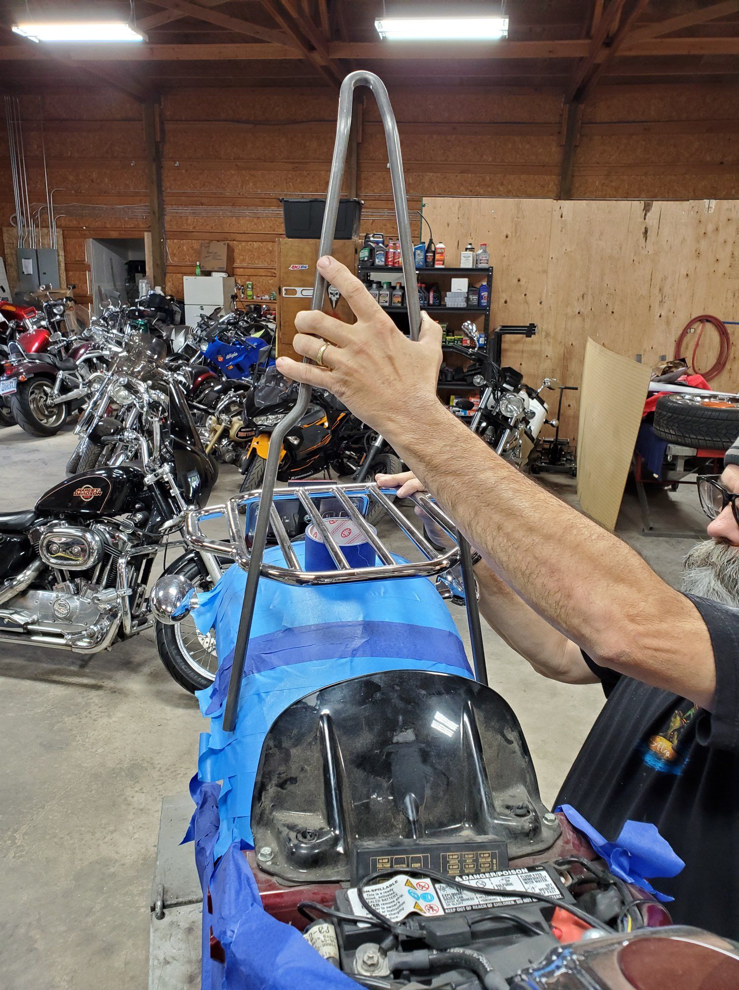 A man is working on a motorcycle in a garage.