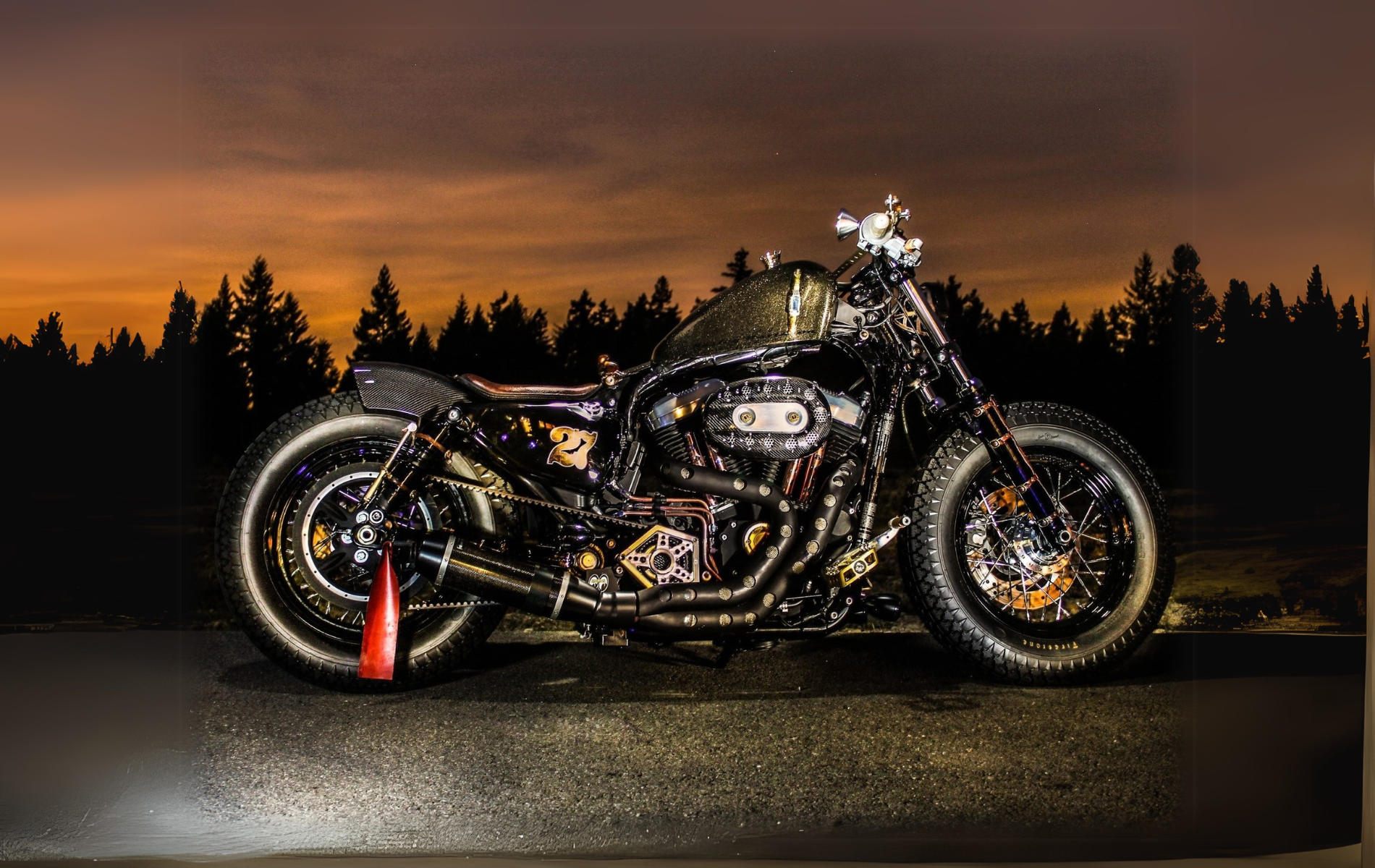 A motorcycle is parked on the side of the road at night.