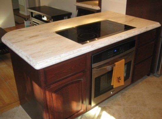 A kitchen island with a stove top oven and microwave