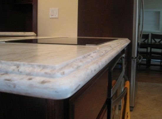 A kitchen with a stove top oven and a refrigerator