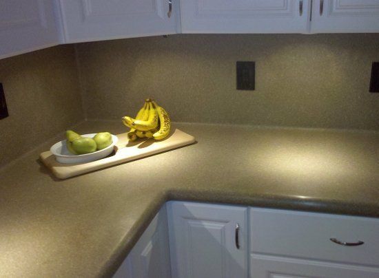 A kitchen counter with bananas and pears on it
