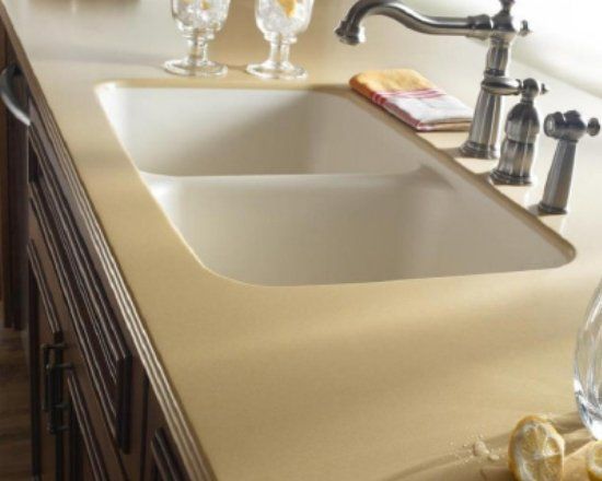 A kitchen sink with a bottle of water on the counter