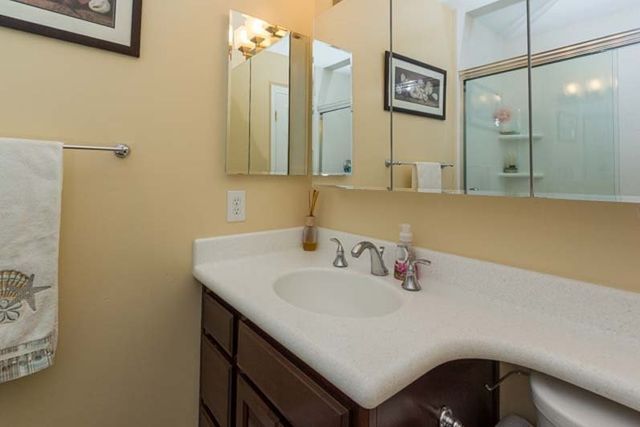 A bathroom with a sink , toilet and mirror.