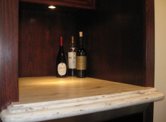 Two bottles of wine are sitting on a wooden counter