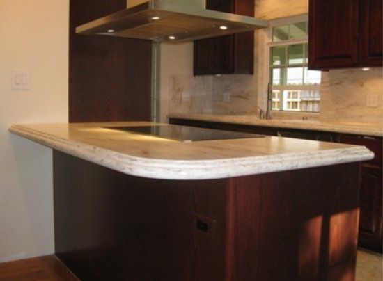 A kitchen with brown cabinets and white counter tops.