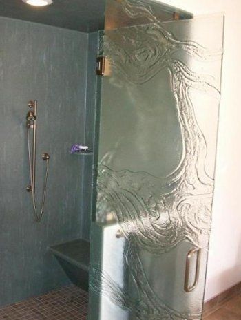 A bathroom with a walk in shower and a glass door