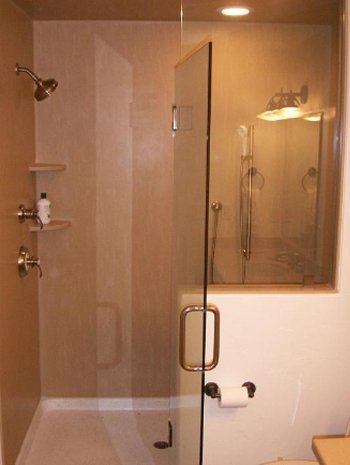 A bathroom with a walk in shower and a toilet.