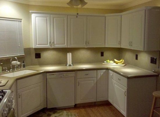 A kitchen with white cabinets and granite counter tops.