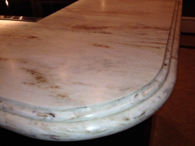 A close up of a white marble counter top in a kitchen.