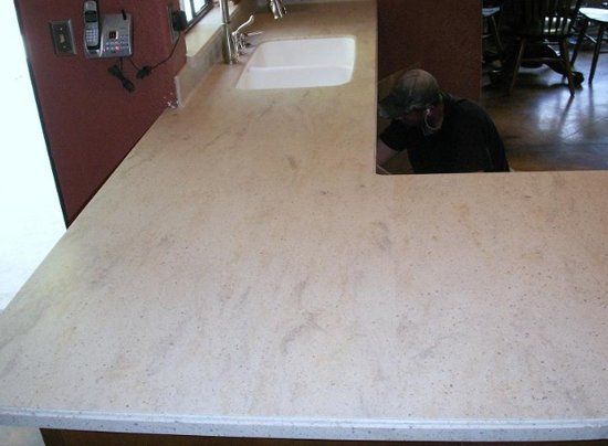 A kitchen counter with a sink and a mirror.