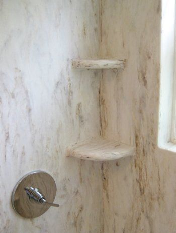 A shower with a corner shelf and a window.