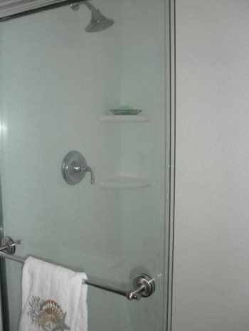 A shower stall with a towel rack and a shower head.