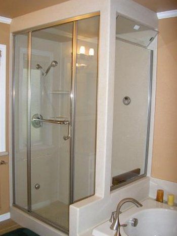 A bathroom with a walk in shower and a sink.