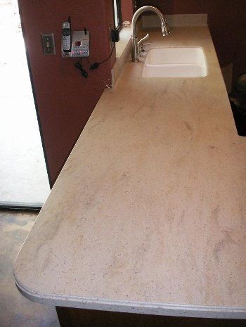 A kitchen counter with a sink and a telephone on it.