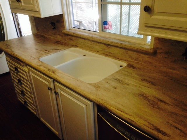 A kitchen counter with a sink and a window