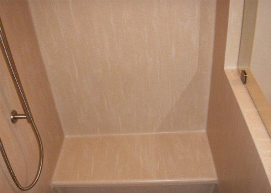 A bathroom with a shower and a bench.