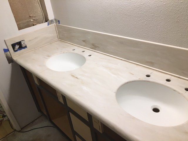 A bathroom counter with two sinks and a mirror
