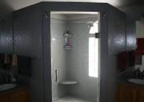 A bathroom with a shower stall and a window.