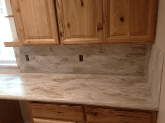 A kitchen with wooden cabinets and a granite counter top.