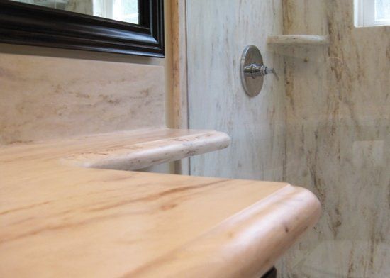 A bathroom with a sink , mirror and shower.