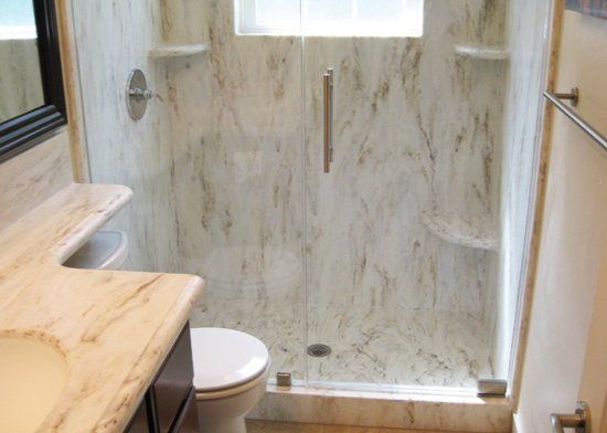 A bathroom with a toilet and a walk in shower.