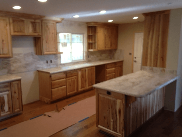A kitchen with wooden cabinets and marble counter tops is being remodeled.