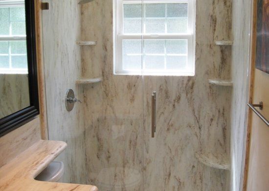 A bathroom with a walk in shower and a window.