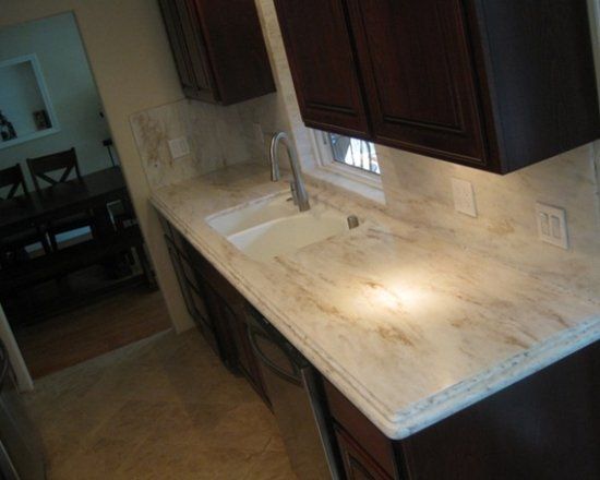 A kitchen with a sink and cabinets and a window