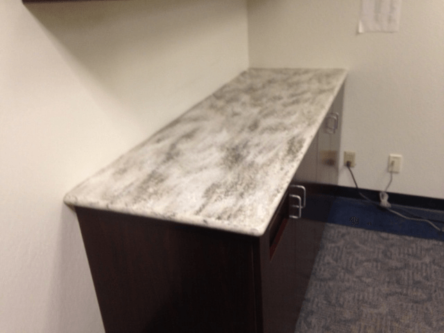 A kitchen counter with a granite counter top in a room.