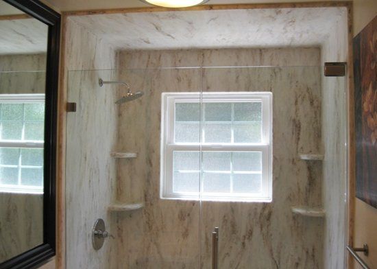 A bathroom with a glass shower door and a window