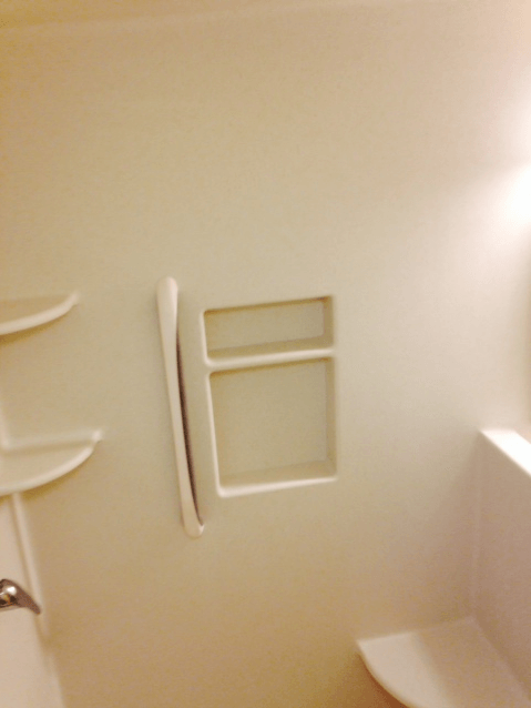 A bathroom with a toilet and shelves on the wall