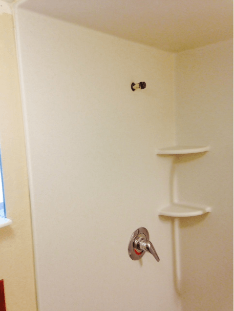 A bathroom with a shower stall and a window