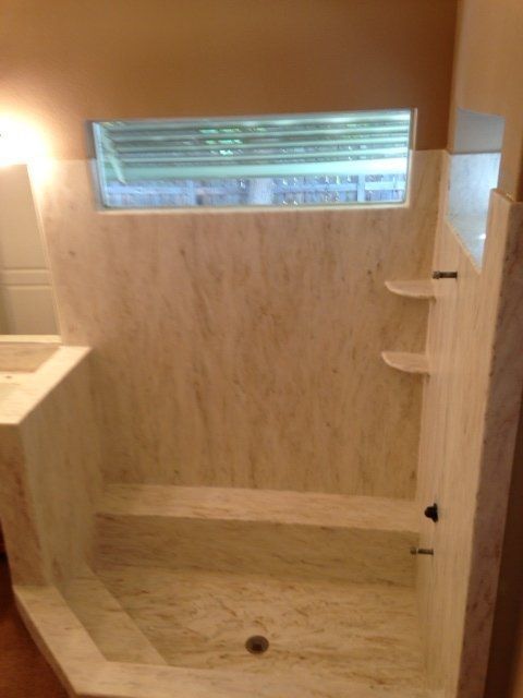 A bathroom with a shower , sink and window
