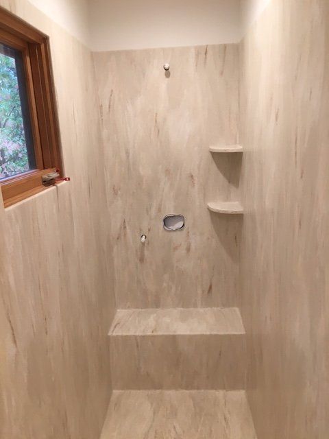 A bathroom with a shower and a window.