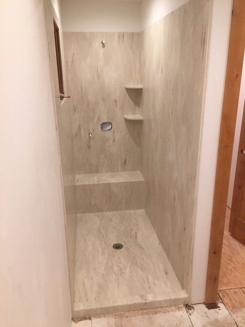 A bathroom with a walk in shower and a window.