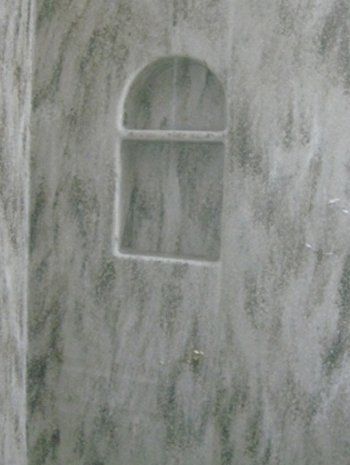 A close up of a shower stall with a shelf in the wall.