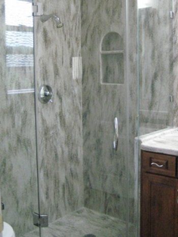 A bathroom with a walk in shower and a sink.